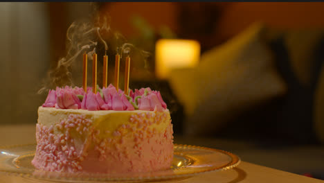 Kerzen-Werden-Auf-Einer-Mit-Zuckerguss-Verzierten-Partytorte-Zum-Geburtstag-Auf-Dem-Heimischen-Tisch-Ausgeblasen-1